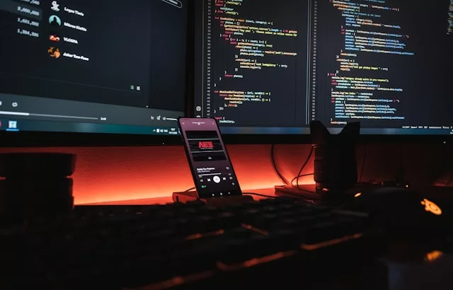 Web development setup with computers and a smartphone.